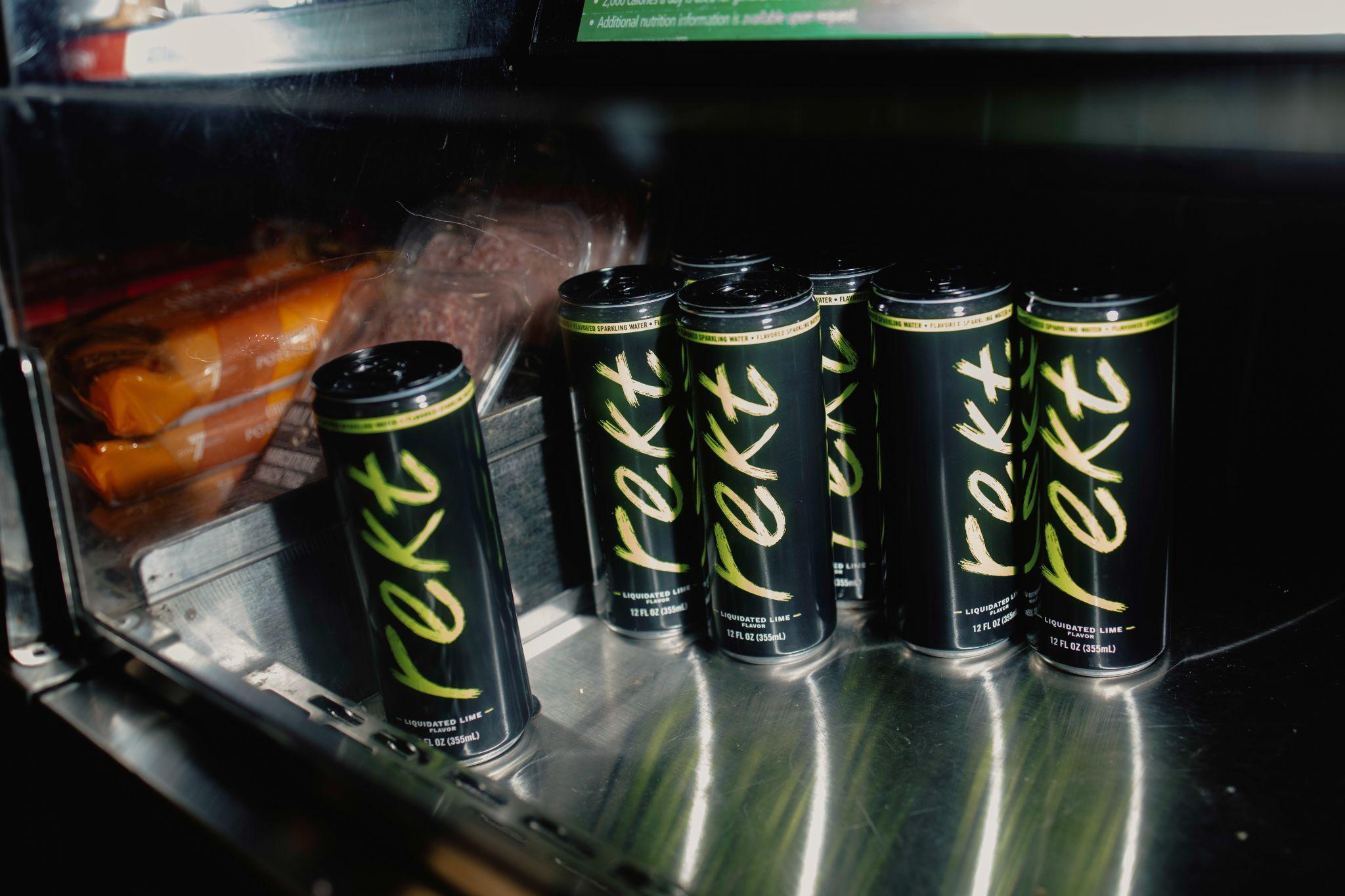 Rekt Drinks cans on a stainless-steel counter, photographed in the original paper.
